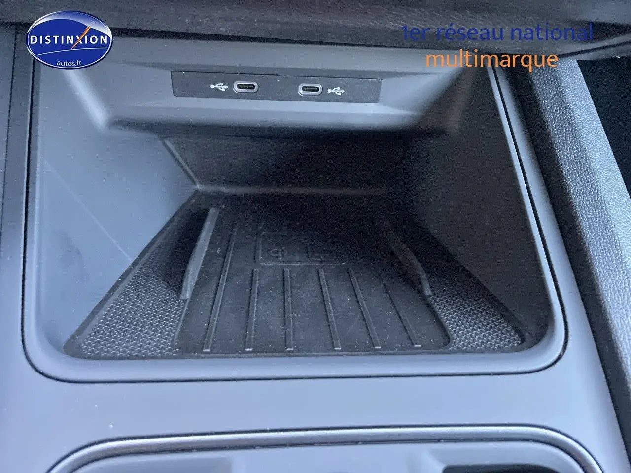 Gros plan sur la console centrale du CUPRA Formentor gris magnétique, montrant la zone de recharge sans fil et ports USB.