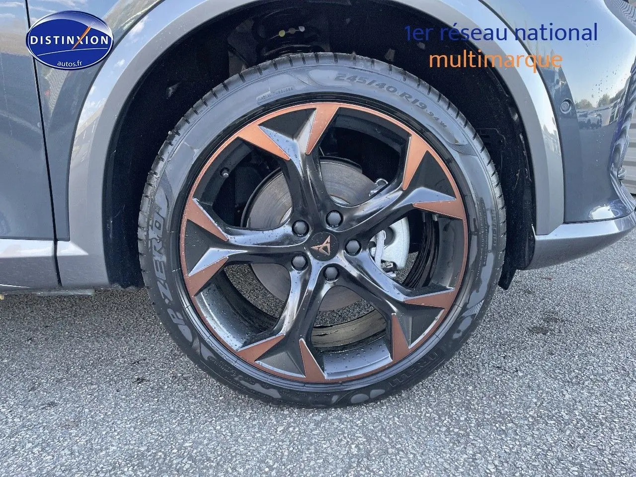 Gros plan sur la roue avant gauche d’un CUPRA Formentor gris magnétique avec jante noire et cuivre en étoile.