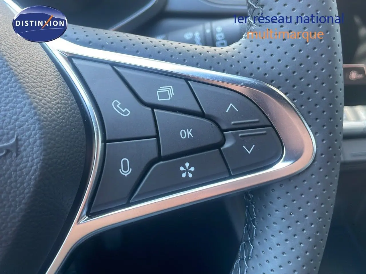Détail du volant en cuir perforé du Renault Captur noir étoile métal, avec commandes multifonctions intégrées.