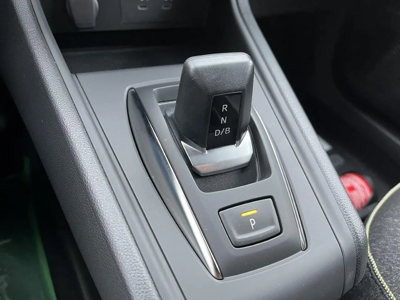 Gros plan sur le levier de vitesses automatique noir et gris du Renault Captur 1.8 E-TECH hybride, avec bouton de parking éclairé.