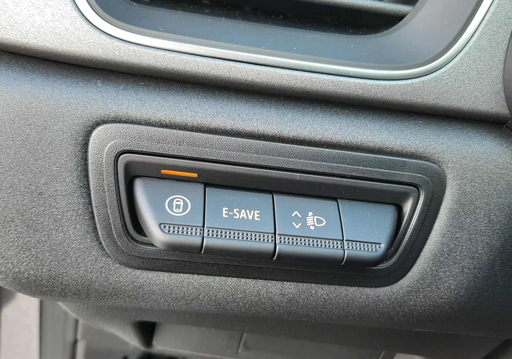 Gros plan sur les boutons de commande du tableau de bord du Renault Captur gris Cassiopée, avec fonction E-SAVE activée.