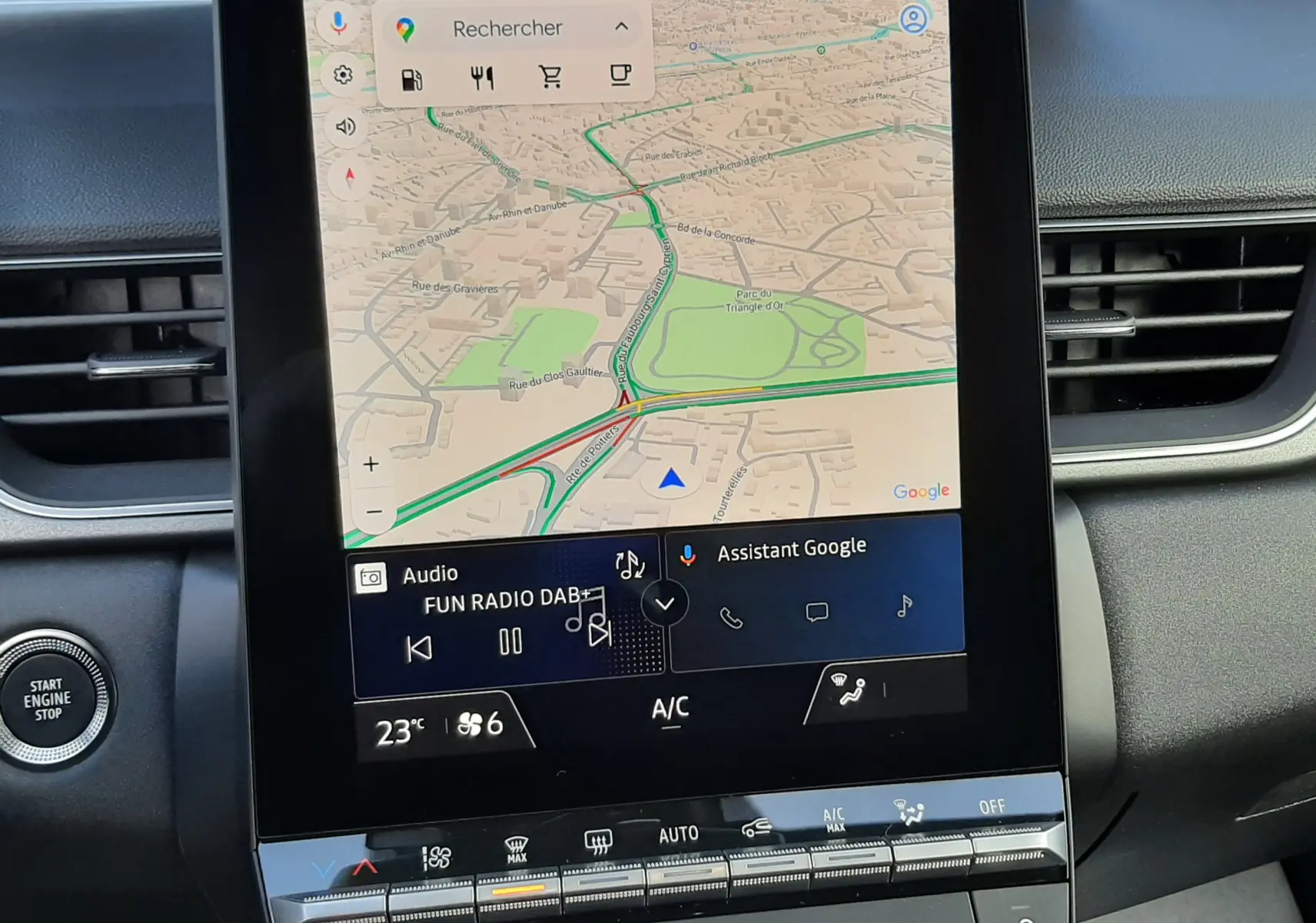 Vue rapprochée de l’écran tactile central du tableau de bord du Renault Captur gris Cassiopée, affichant la navigation GPS et les commandes climatiques.
