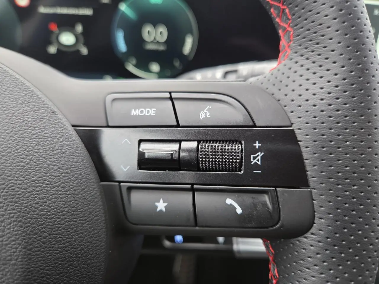 Gros plan sur commandes gauche du volant perforé noir avec surpiqûres rouges du Hyundai Tucson N Line 2025.