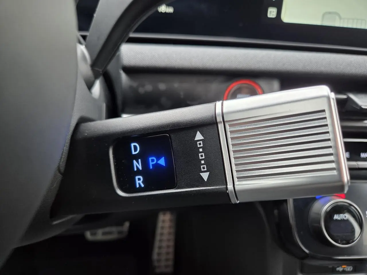 Gros plan sur la commande de boîte automatique du Hyundai Tucson 2025, affichage lumineux bleu sur levier noir et argenté.