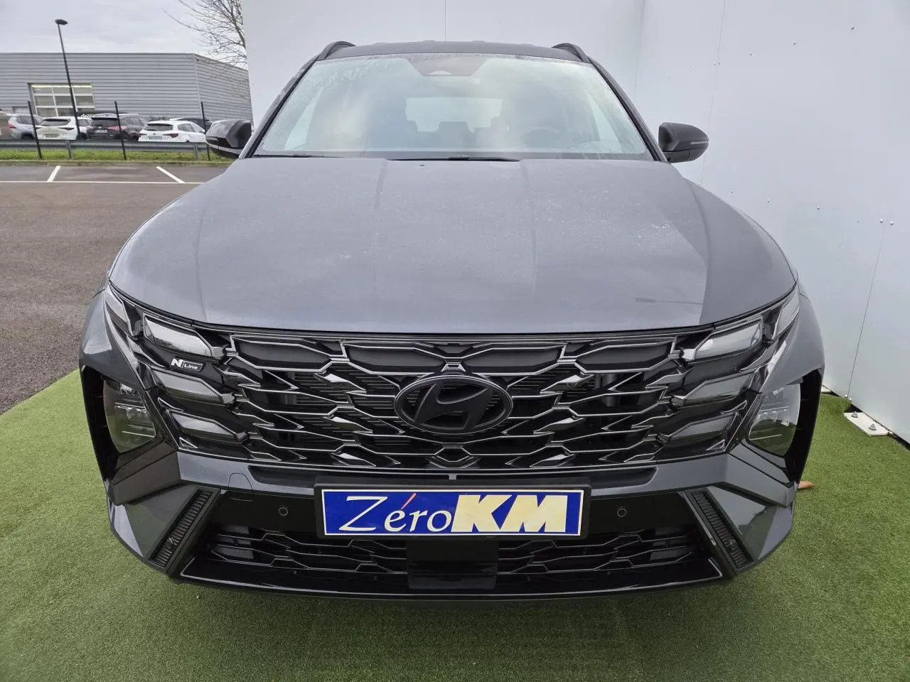 Vue avant centrée du Hyundai Tucson 2025 gris métallisé avec calandre noire N Line et feux LED distinctifs.