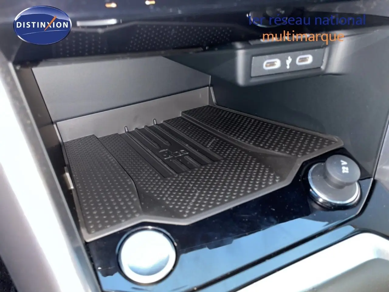 Gros plan sur la zone de recharge sans fil et ports USB du Volkswagen T-Roc noir Grenadilla, intérieur moderne et épuré.