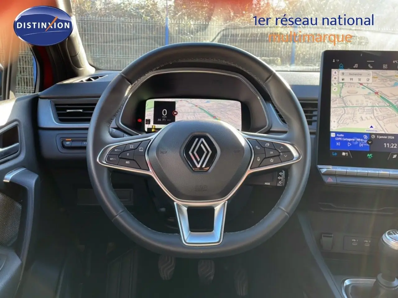Vue intérieure centrée sur le volant noir du Renault Captur 2025 avec tableau de bord numérique et écran tactile GPS.