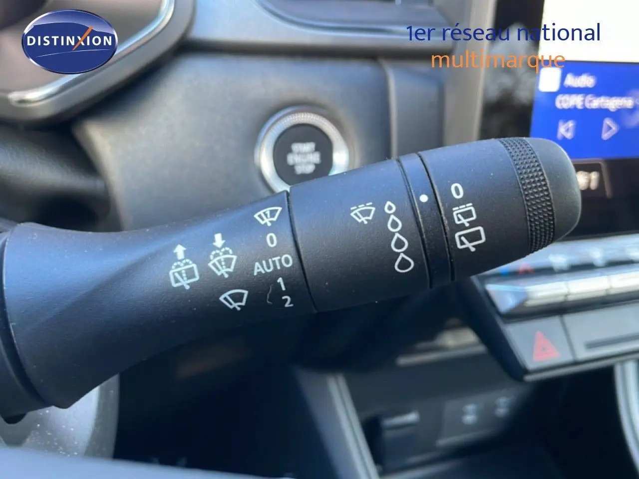 Gros plan sur la commande d’essuie-glace du Renault Captur 2025, intérieur noir avec écran tactile en arrière-plan.