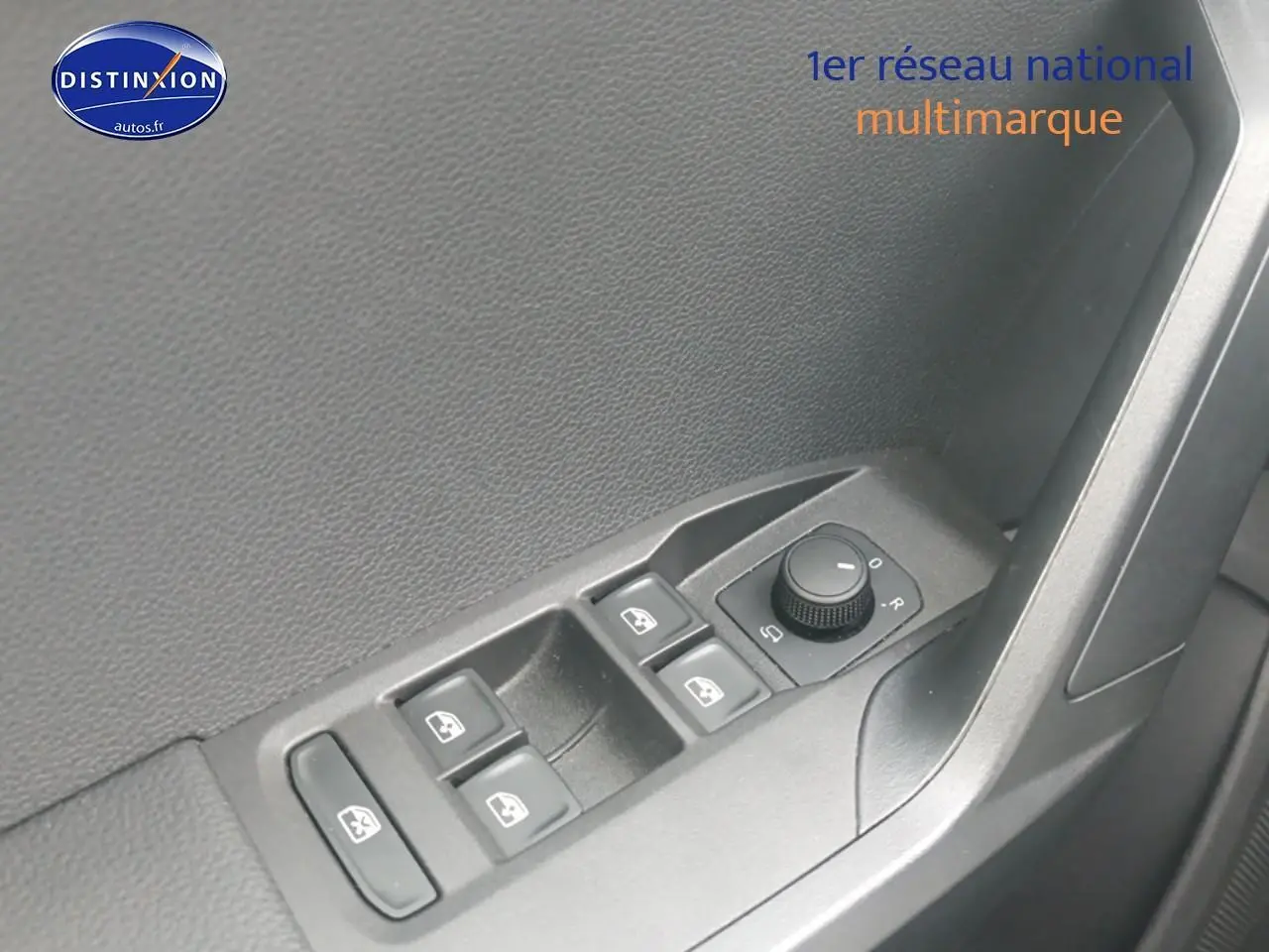 Gros plan sur les commandes de lève-vitres et réglage des rétroviseurs côté conducteur d'une SEAT Ibiza blanc Nevada.