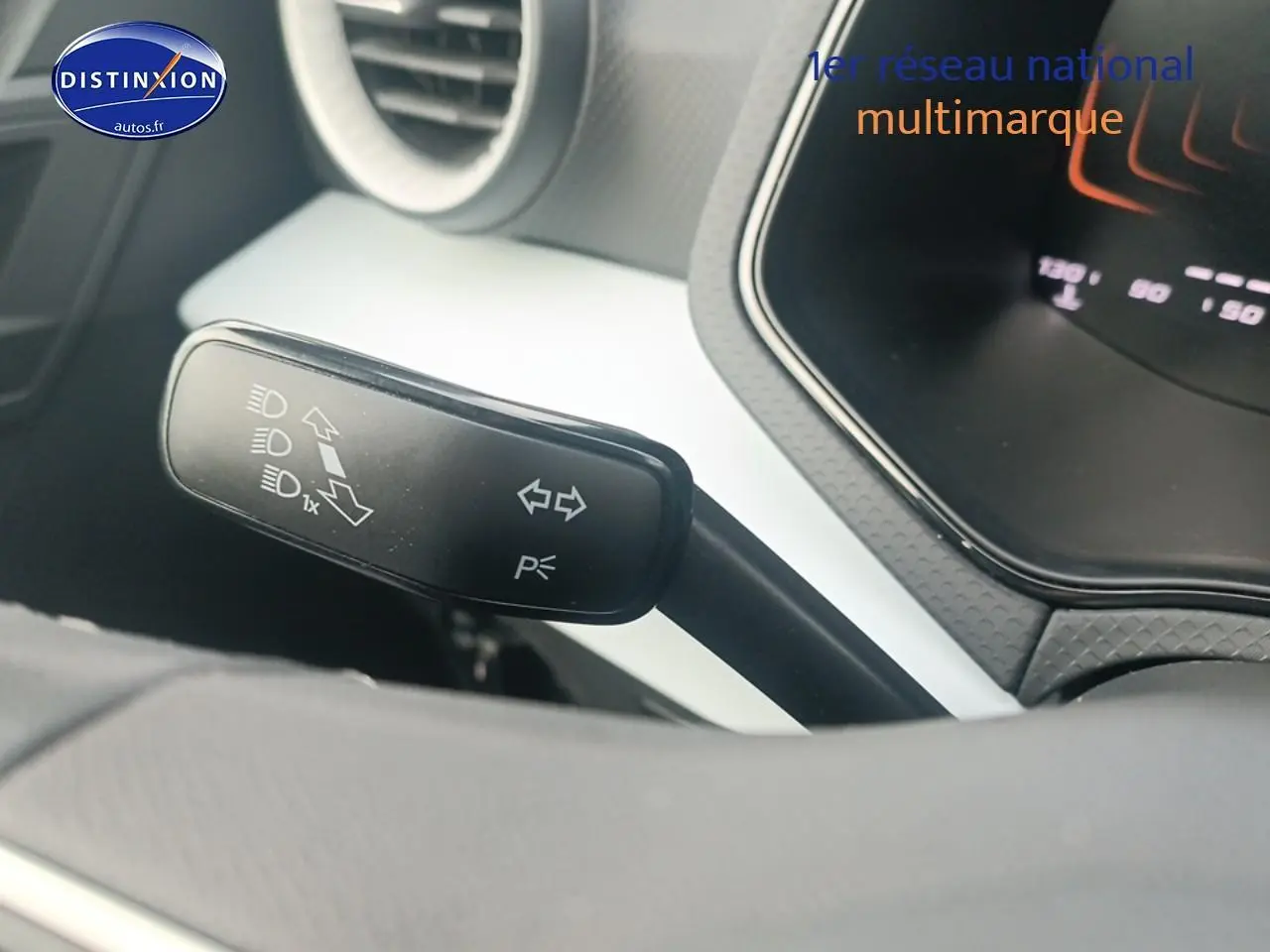 Gros plan sur la commande de clignotants noire à gauche du volant dans l’habitacle blanc et gris de la SEAT Ibiza 2025.