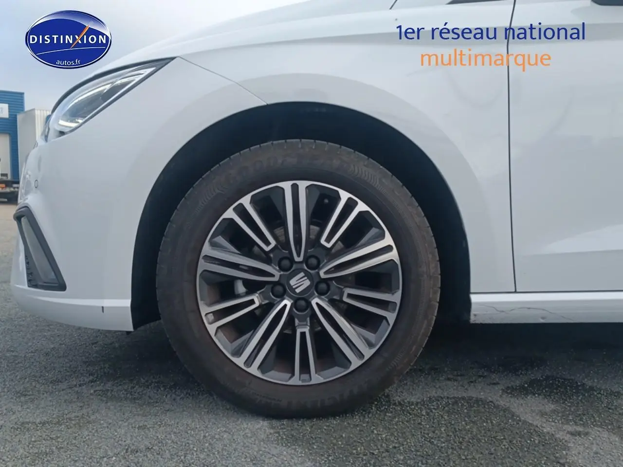 Gros plan sur la roue avant gauche et partie avant blanche d'une SEAT Ibiza 1.0 TSI 95 Copa avec jante design 16 pouces.