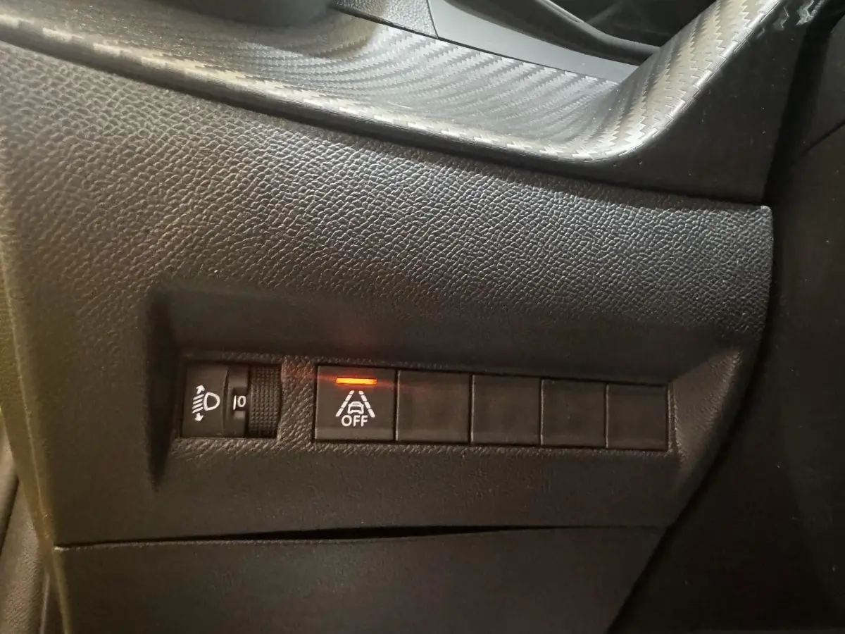 Gros plan sur les commandes noires du tableau de bord côté gauche de la Peugeot 208 jaune PureTech 75 S&S Active Pack 2023.