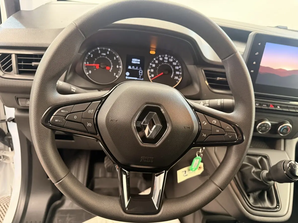 Vue rapprochée du volant multifonctions noir du Renault Kangoo 2023 avec tableau de bord et levier de vitesse manuel.
