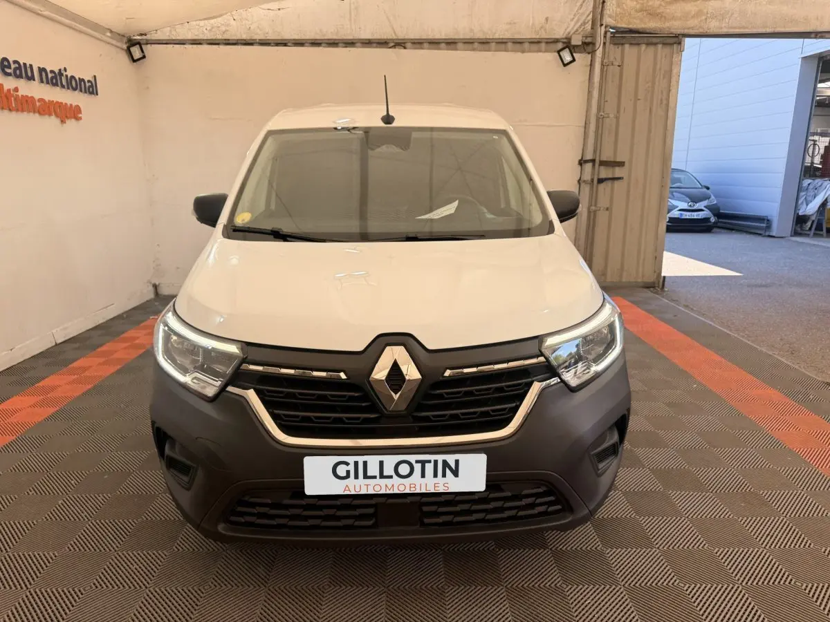 Vue frontale d’un Renault Kangoo blanc 2023 avec calandre noire et logo Renault proéminent.