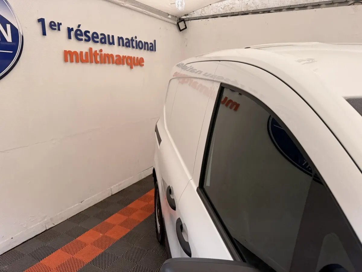 Vue 3/4 arrière côté droit du Renault Kangoo blanc GD Confort 2023, avec vitres latérales teintées et poignées noires.
