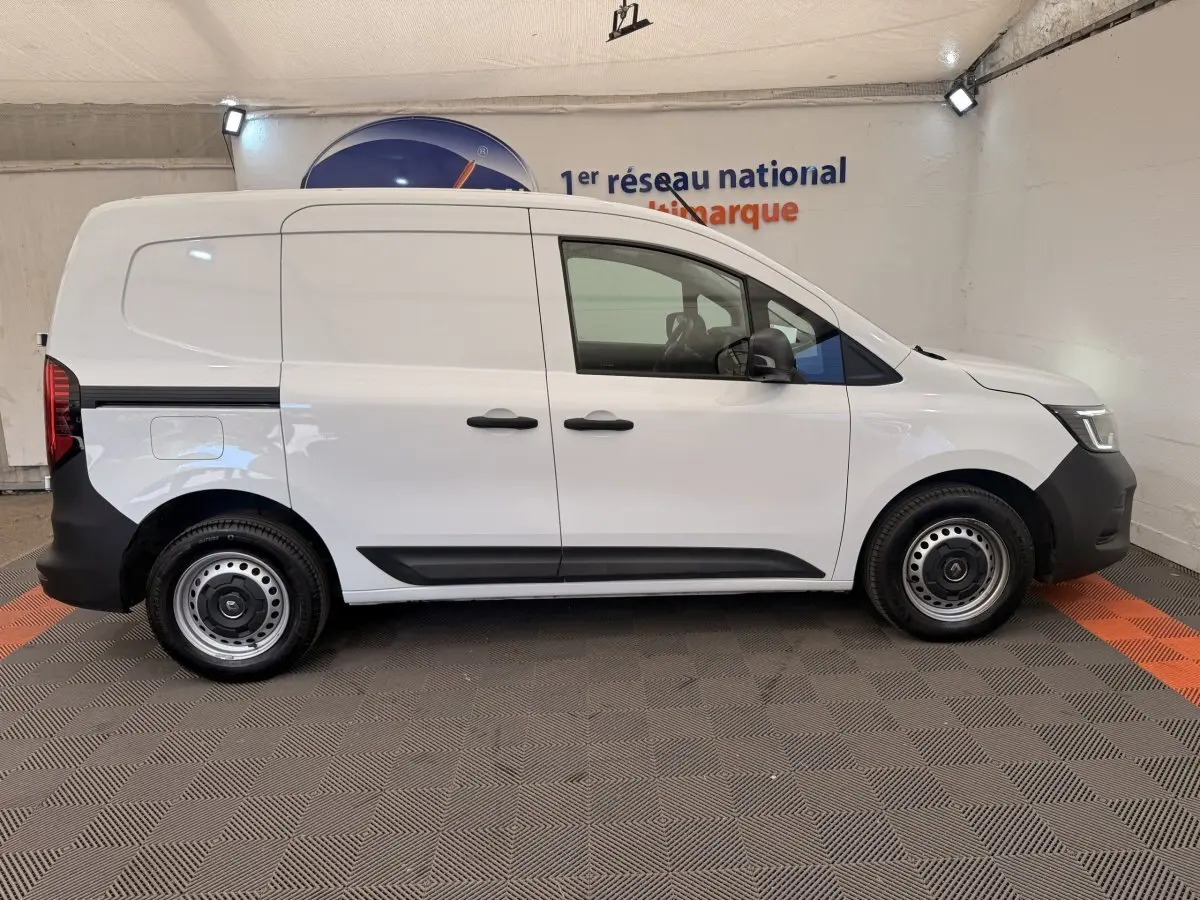 Vue latérale droite d’un Renault Kangoo blanc 2023 version GD Confort avec jantes acier et portes coulissantes.