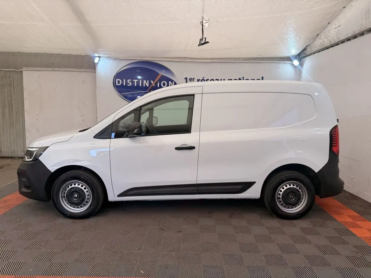 Vue latérale droite d’un Renault Kangoo blanc 2023, fourgon utilitaire avec jantes acier et pare-chocs noirs.
