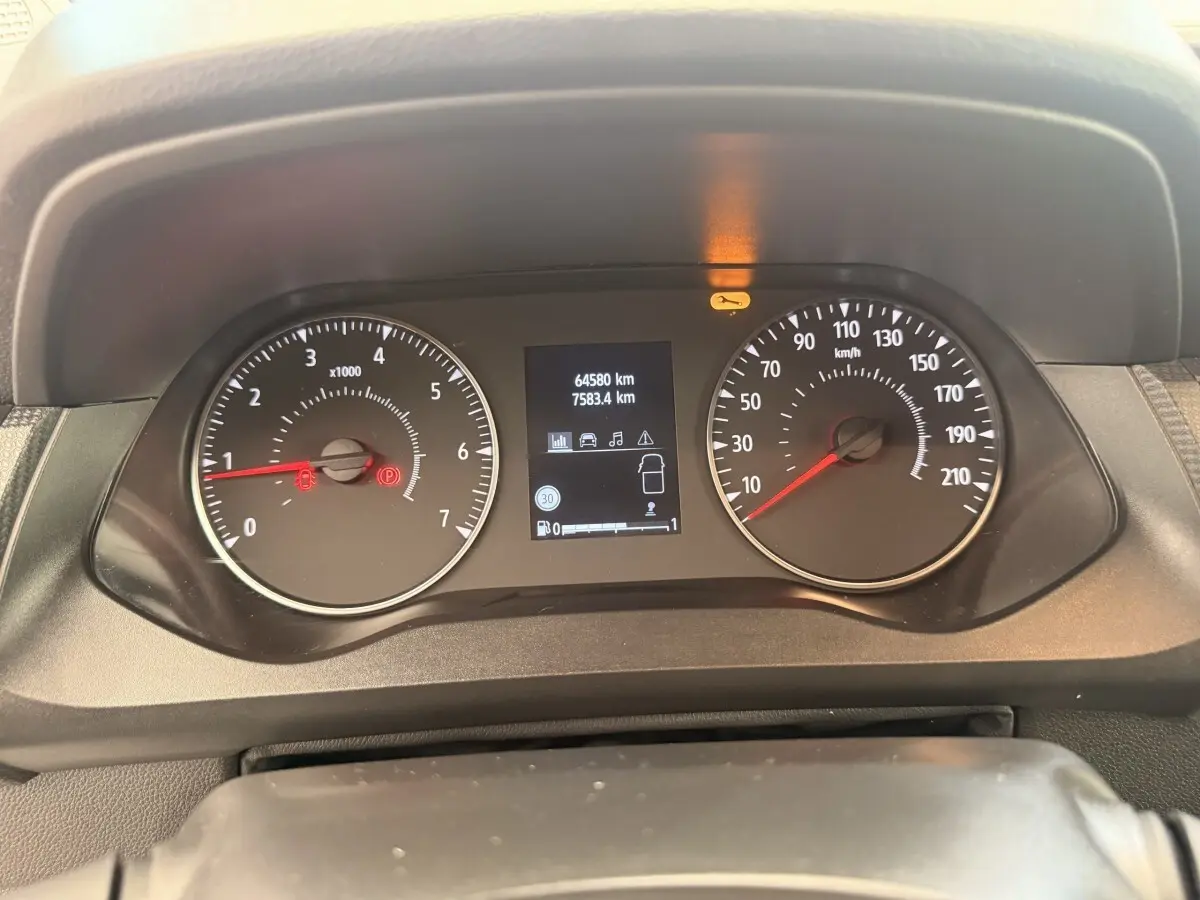Vue rapprochée du tableau de bord du Renault Kangoo blanc 2023, affichage digital et compte-tours analogiques.