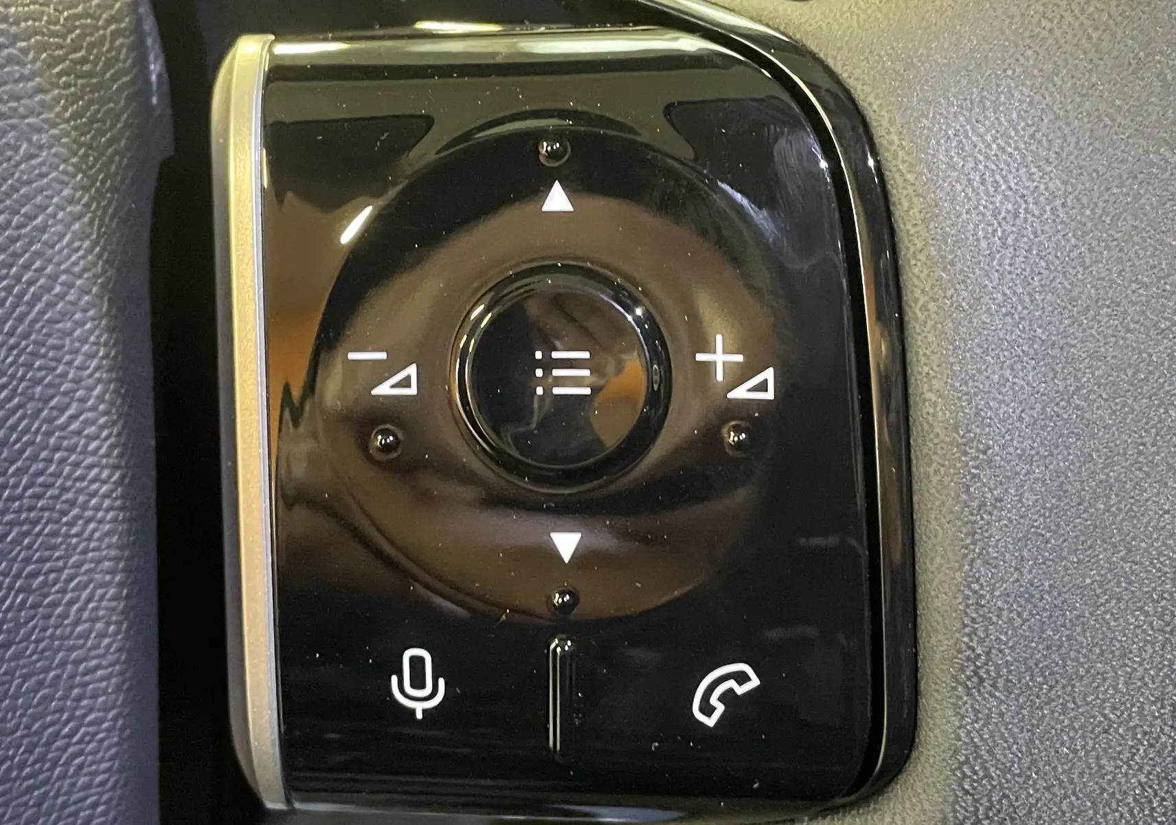 Gros plan sur les commandes au volant noir brillant du Citroën C5 Aircross hybride 2026, boutons volume et appel.