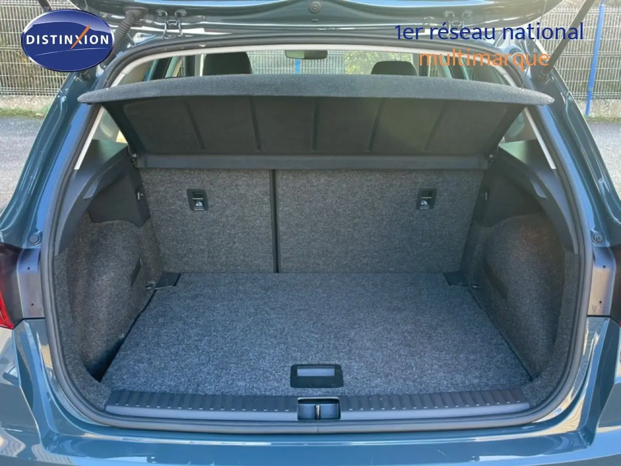 Coffre ouvert vu de l'arrière d'un SEAT Arona gris Fiord avec toit blanc, montrant un espace de chargement propre et spacieux.