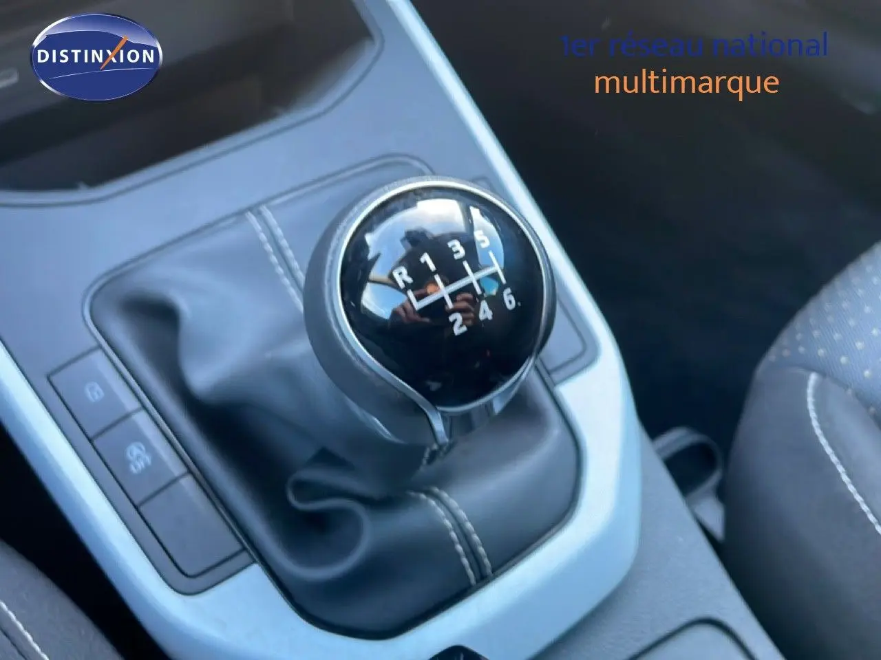 Gros plan sur le levier de vitesses manuel noir de la SEAT Arona 2025, intérieur tissu gris avec surpiqûres blanches.