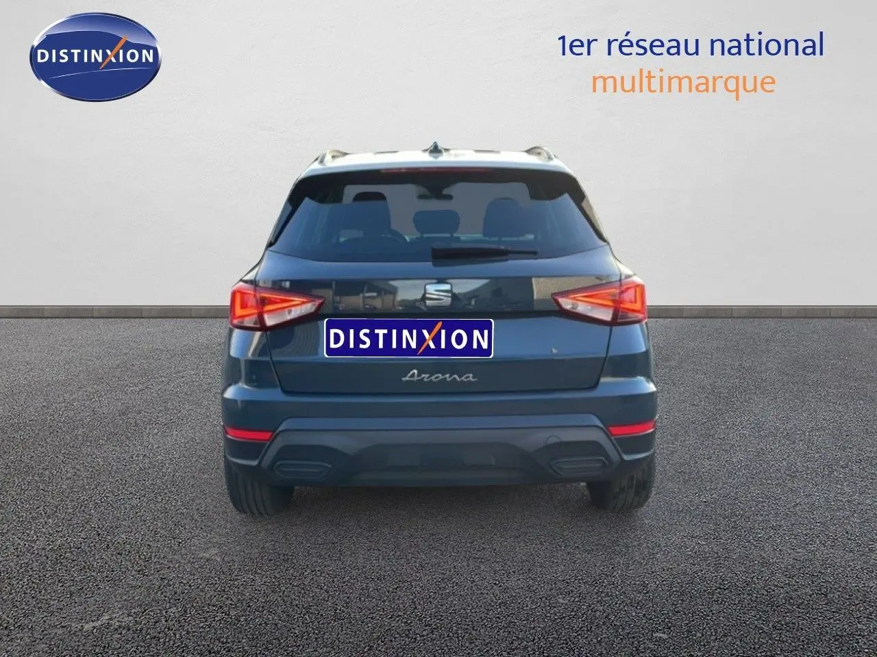 Vue arrière d’un SEAT Arona gris Fiord avec toit blanc, feux arrière allumés sur fond neutre.