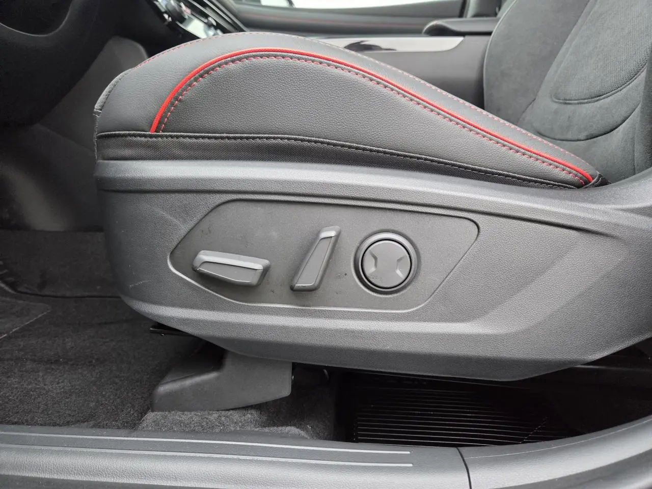 Détail des commandes électriques du siège avant gauche en cuir noir avec surpiqûres rouges du Hyundai Tucson 2025.