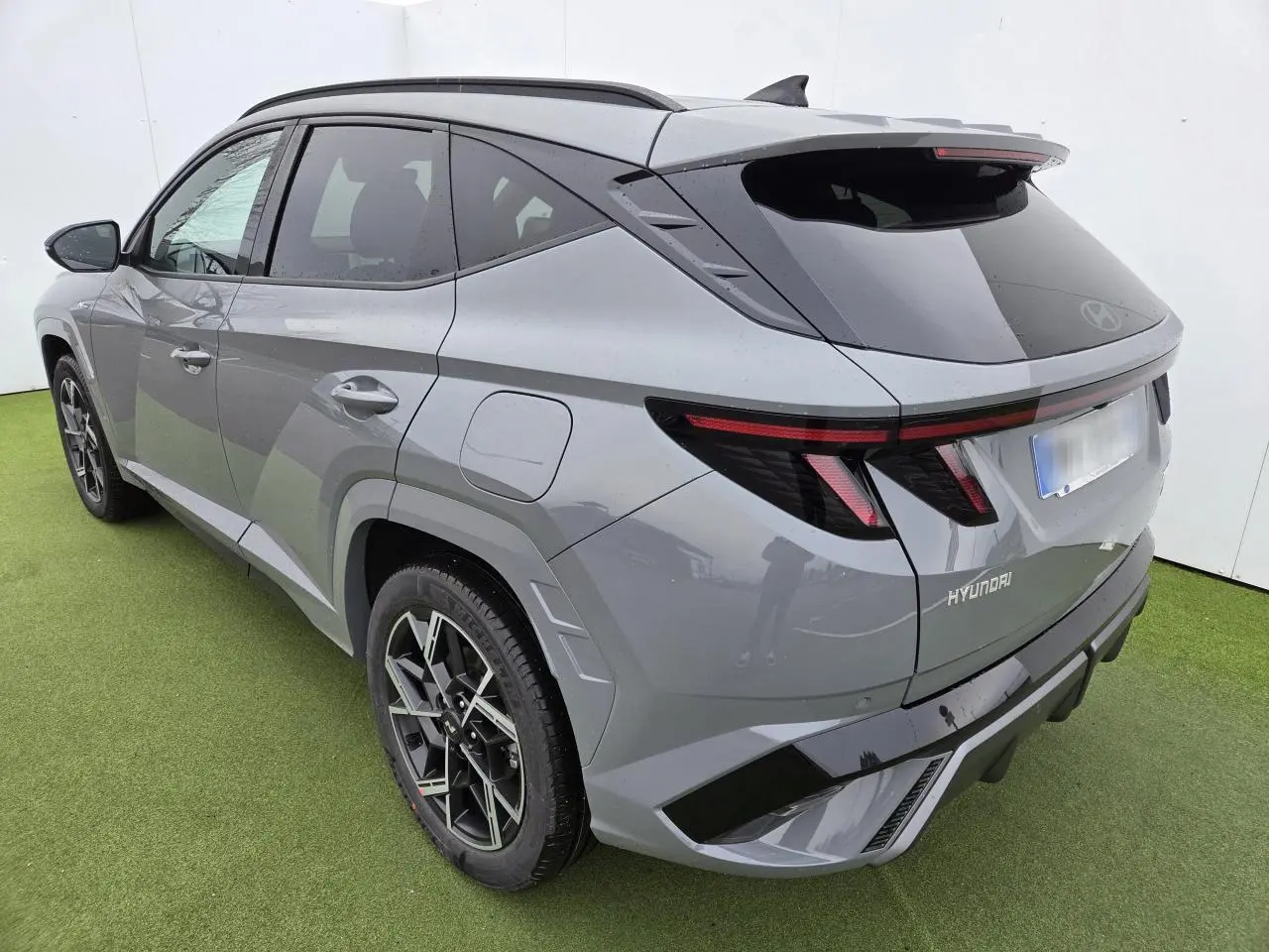 Vue 3/4 arrière droite du Hyundai Tucson 2025 gris métallisé avec jantes alliage 19'' N Line et feux arrière LED.