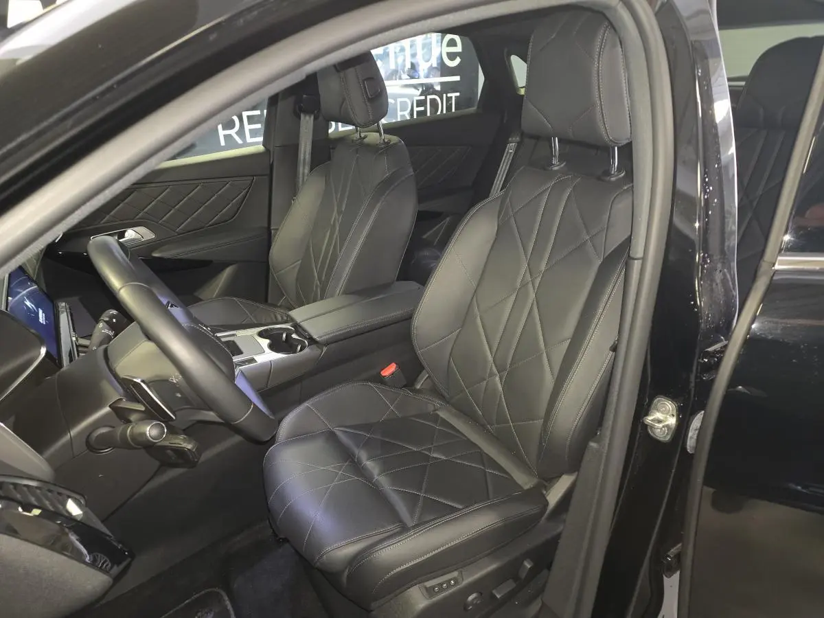 Vue intérieure côté conducteur du DS7 Crossback E-Tense 225 Rivoli noir, sièges cuir noir matelassé et console centrale visible.