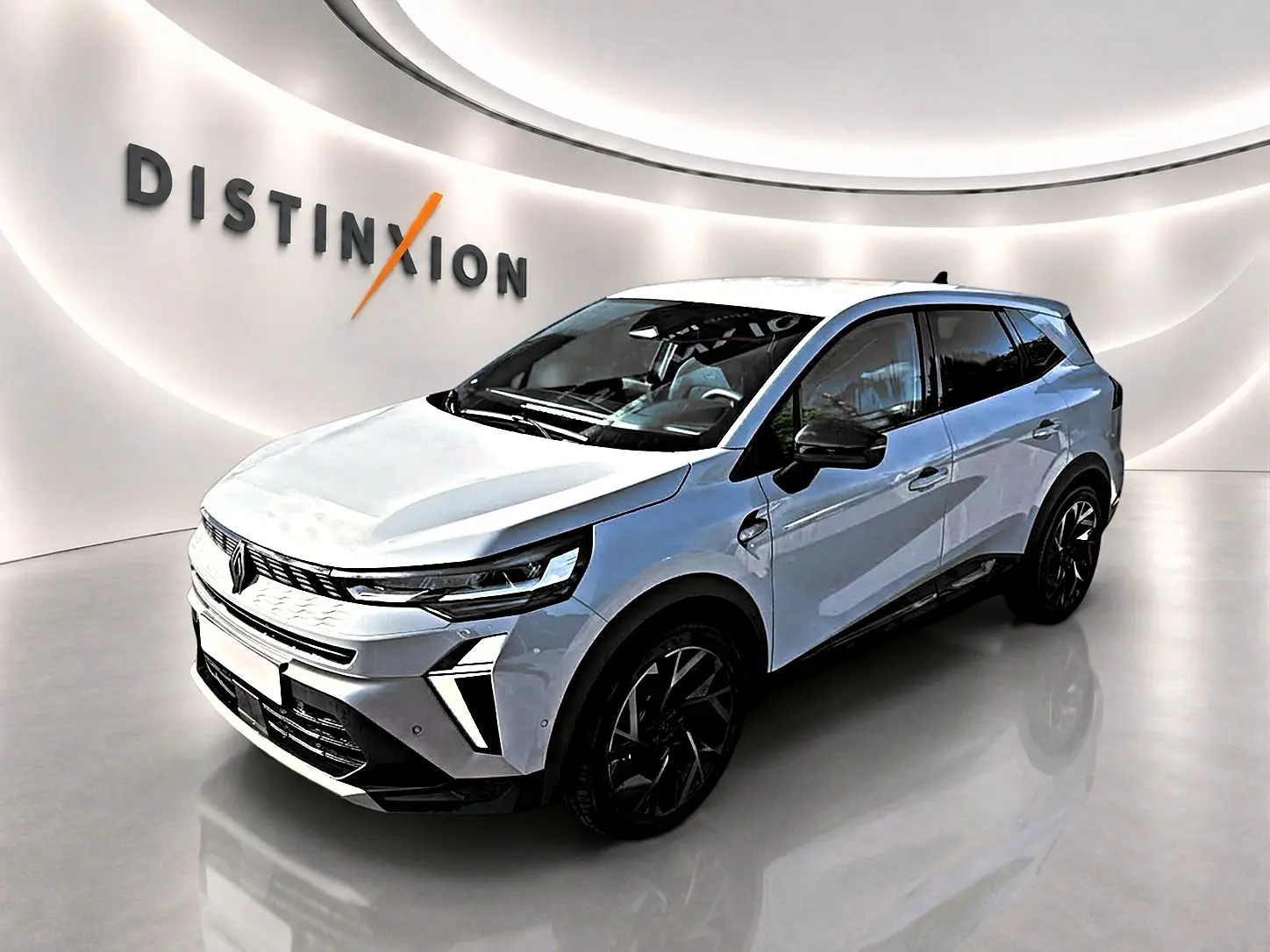 Renault Symbioz gris rafale en 3/4 avant droit, SUV hybride avec jantes noires et détails noirs contrastants.