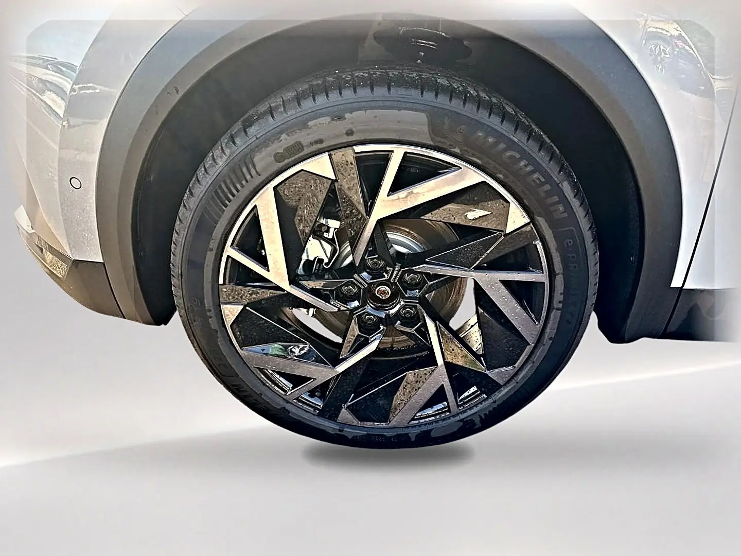 Gros plan sur la roue avant gauche du Renault Symbioz gris rafale, mettant en valeur la jante alu au design géométrique noir et argent.