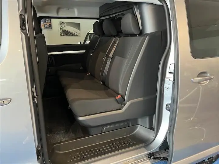 Vue latérale intérieure montrant les sièges noirs du FIAT Scudo Cabine Approfondie gris Artense avec porte coulissante ouverte.