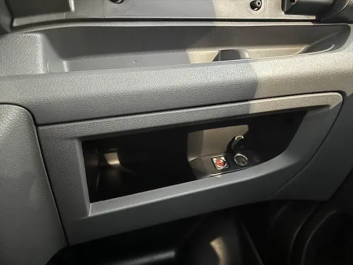 Gros plan sur la boîte à gants grise du Fiat Scudo Cabine Approfondie avec ouverture et prise allume-cigare visible.
