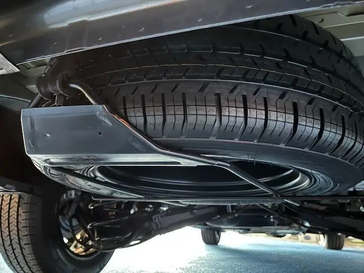 Gros plan sous le FIAT Scudo cabine approfondie gris Artense, montrant la roue de secours fixée sous le châssis.