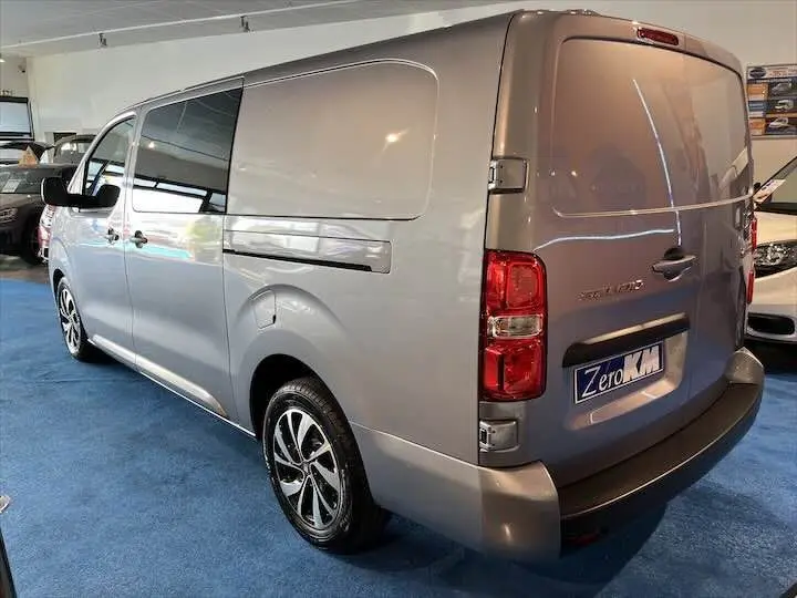 Vue 3/4 arrière droite d'un FIAT Scudo cabine approfondie gris Artense métal avec jantes alliage et vitres teintées.