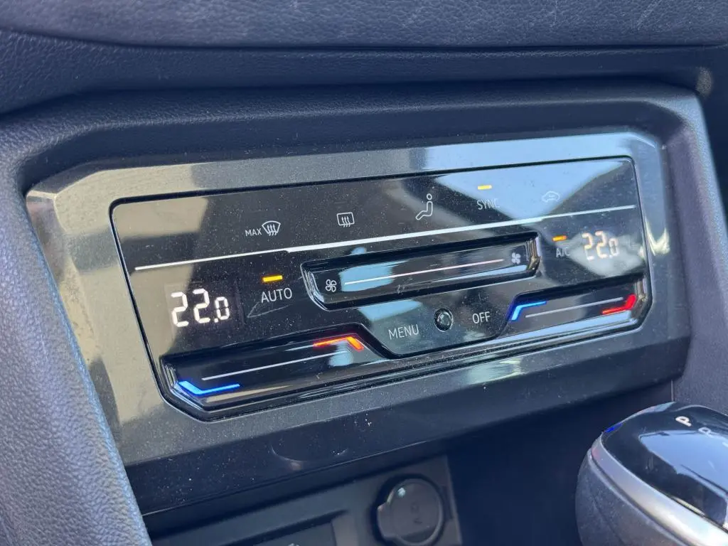 Panneau de commande de la climatisation automatique du Volkswagen Tiguan 2.0 TDI gris, affichant 22°C en mode auto.