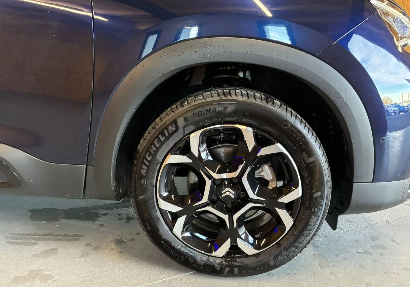 Gros plan sur la roue avant droite du Citroën C5 Aircross bleu Eclipse Métal avec jante noire et argentée distinctive.
