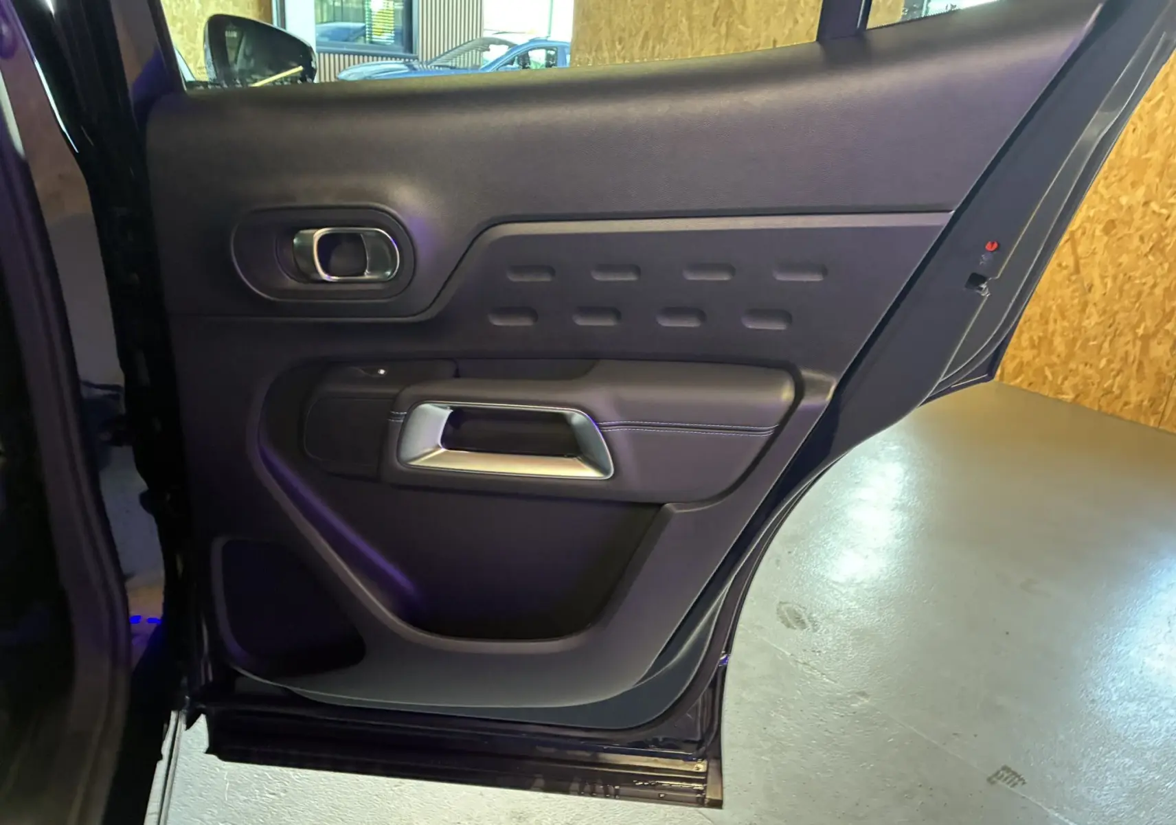 Porte arrière gauche ouverte du Citroën C5 Aircross bleu Eclipse Metal, montrant le panneau intérieur noir avec poignée argentée.