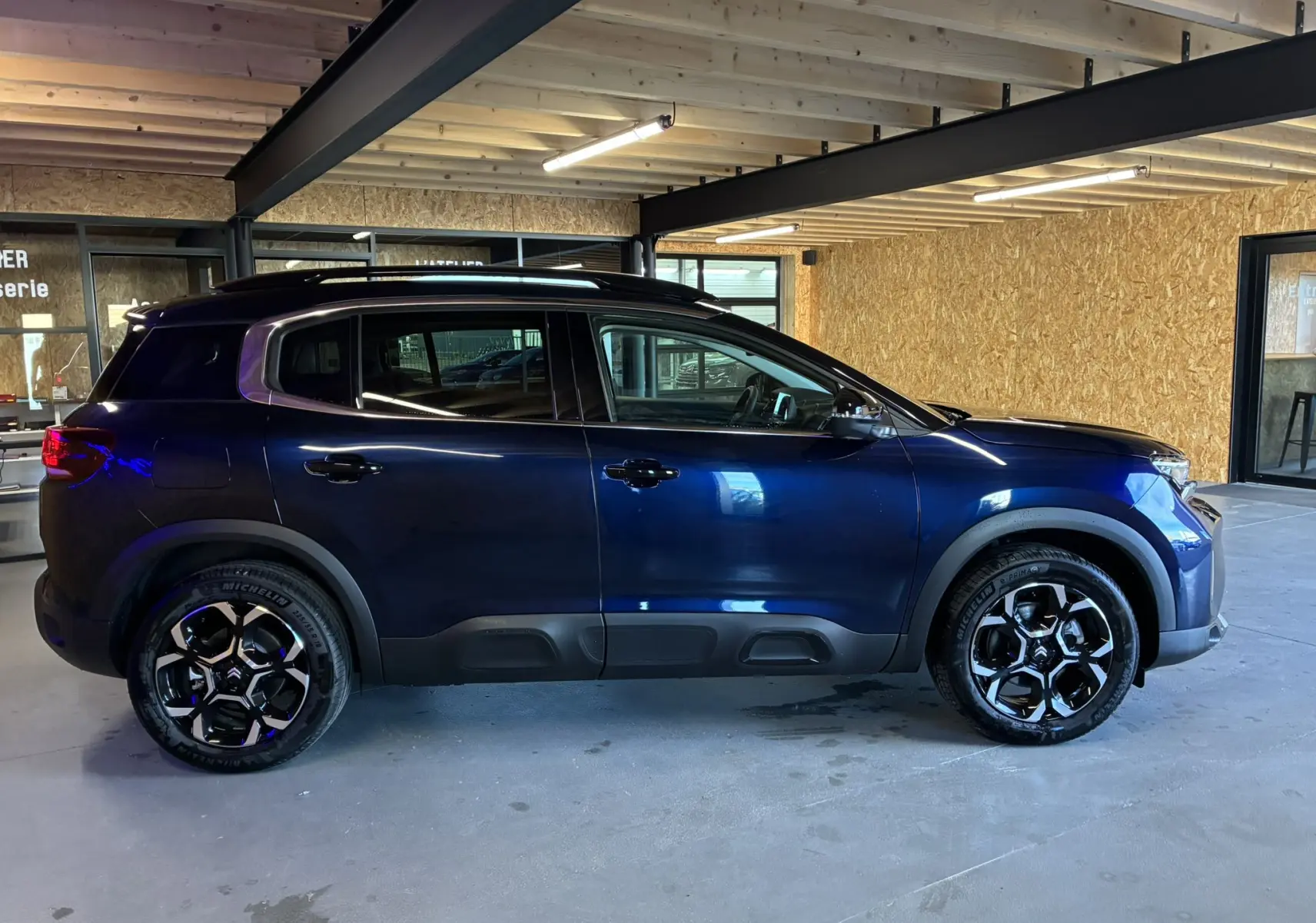 Profil côté gauche du Citroën C5 Aircross bleu Eclipse Métal, avec jantes noires et détails noirs sur les bas de caisse.