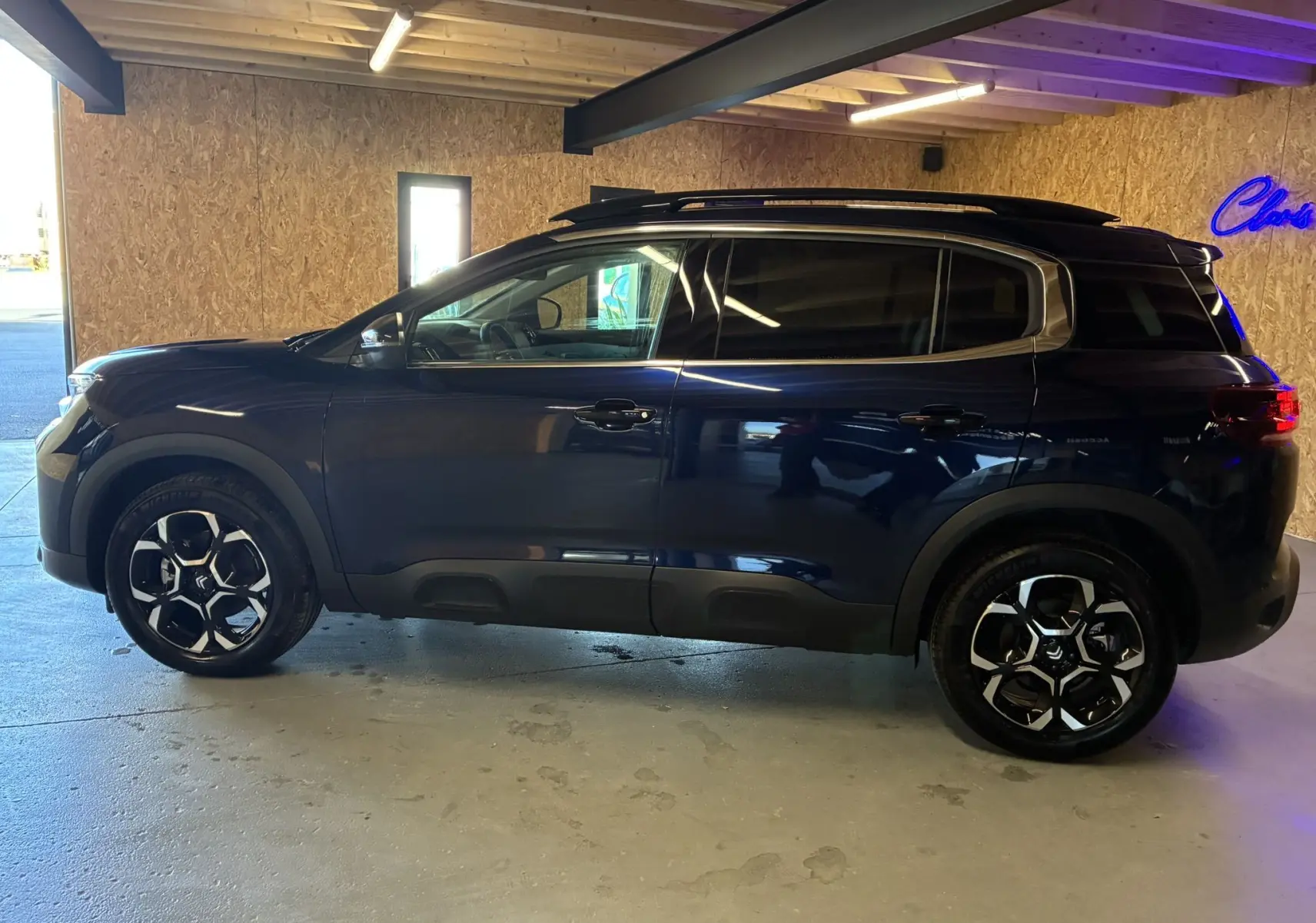 Profil côté gauche du Citroën C5 Aircross bleu Eclipse Métal, avec jantes alliage et toit noir en intérieur lumineux.