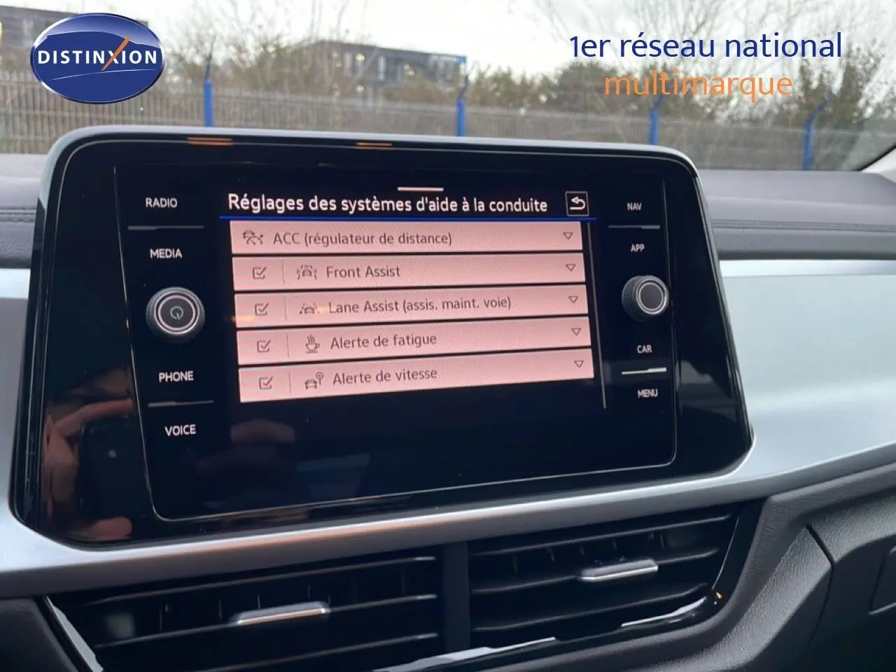 Écran central tactile du Volkswagen T-Roc affichant les réglages des aides à la conduite, intérieur noir.