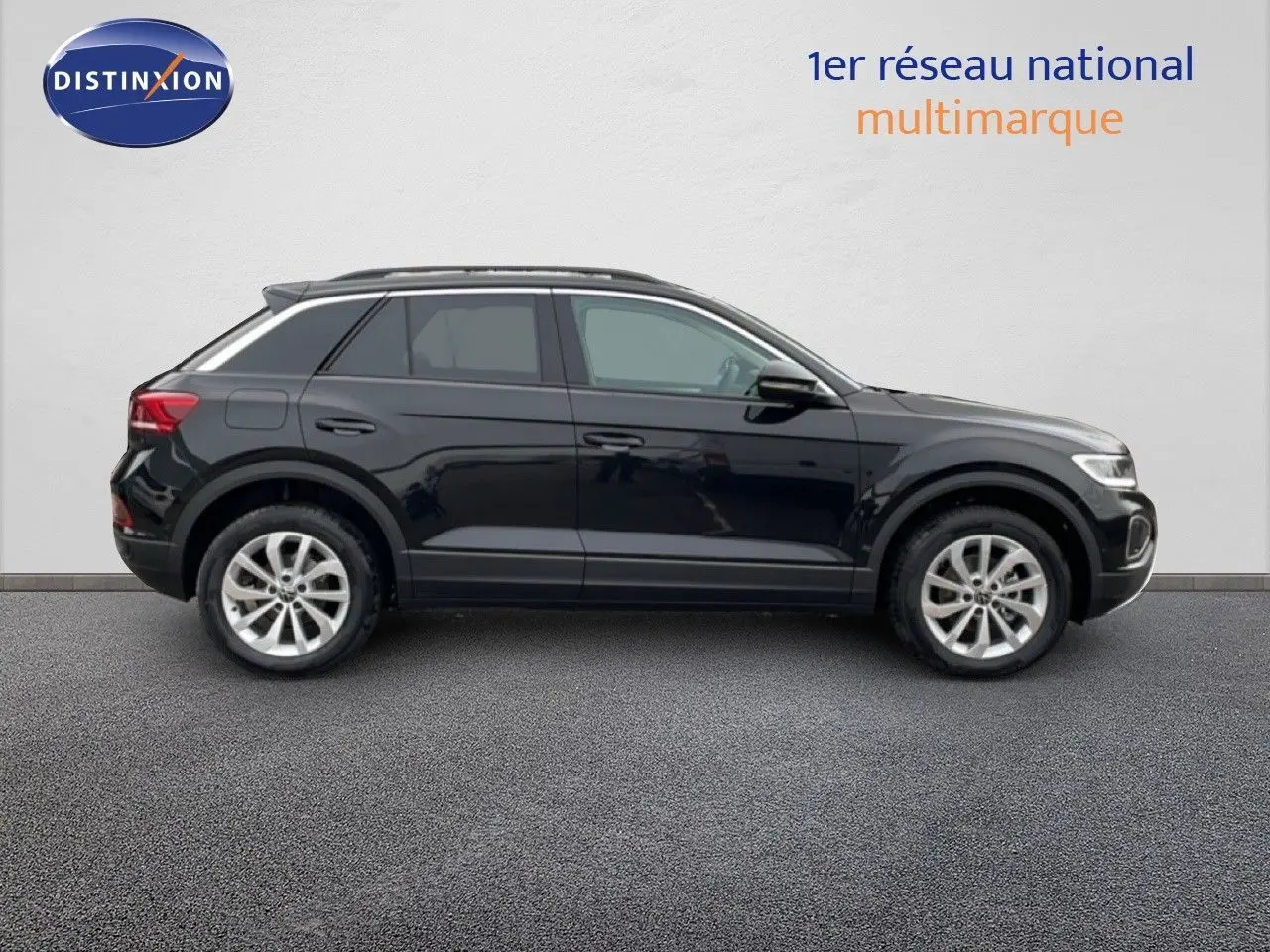 Profil latéral droit d’un Volkswagen T-Roc noir Grenadilla métallisé, avec jantes alliage et toit ouvrant visible.