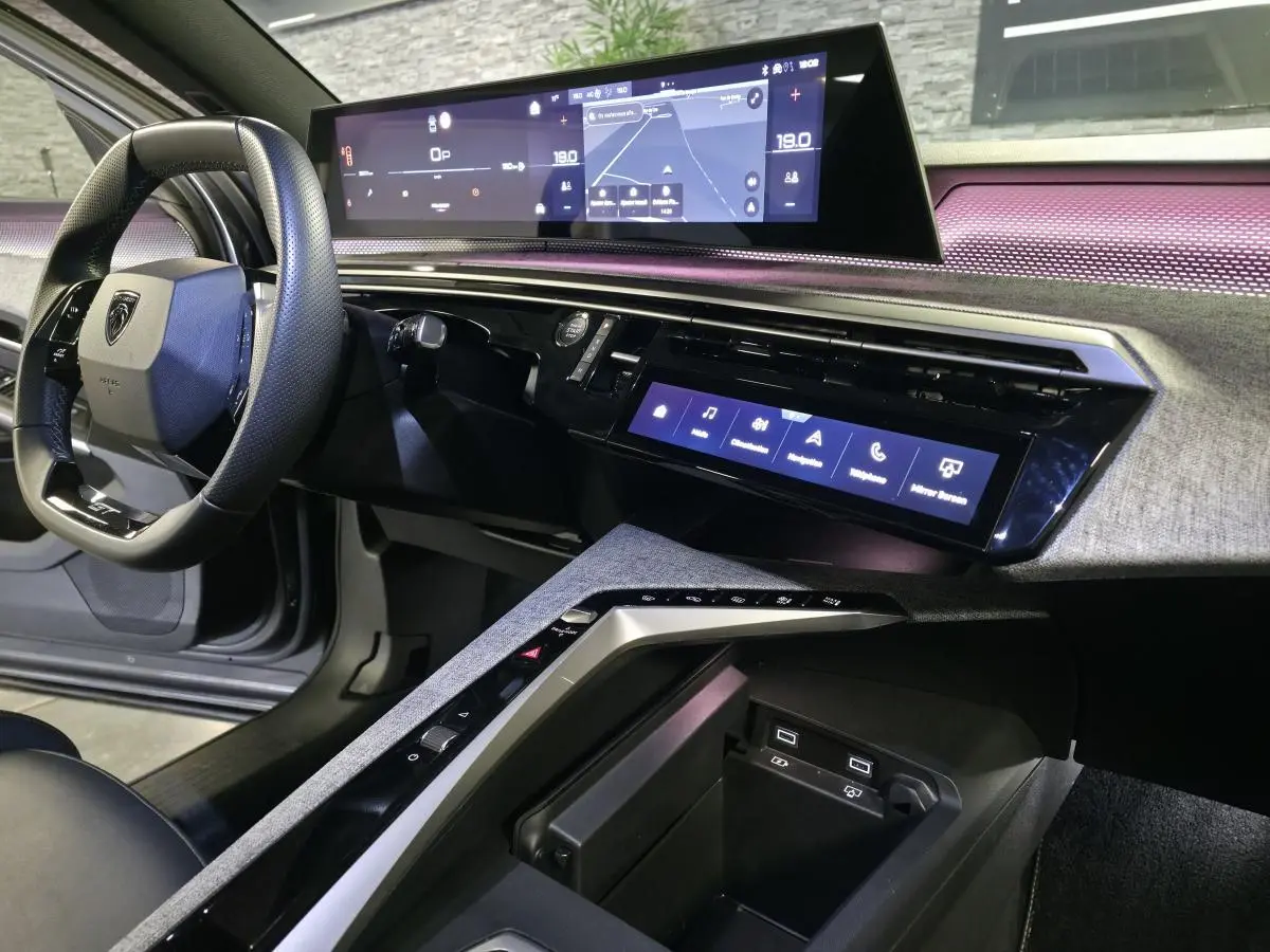 Vue intérieure côté conducteur du Peugeot 3008 gris 2025, avec tableau de bord numérique panoramique et console centrale moderne.