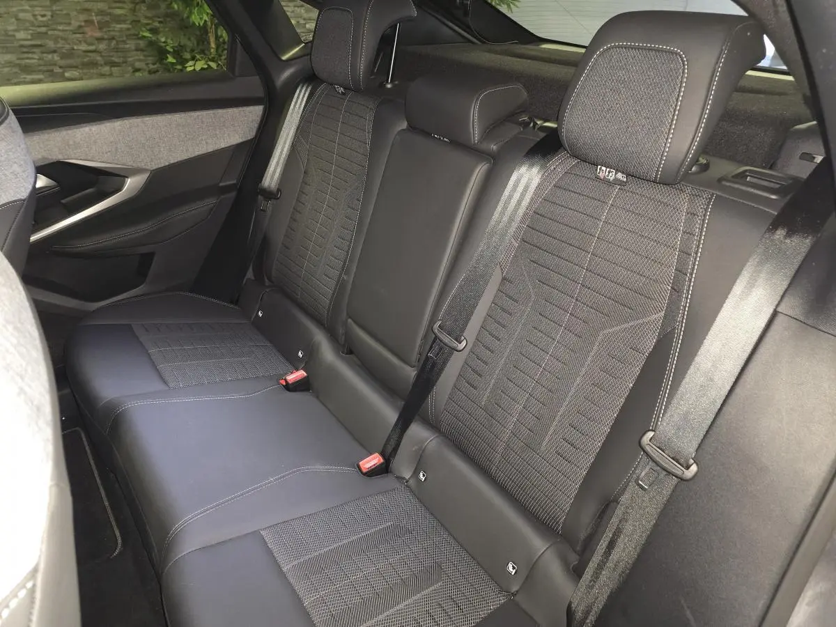 Vue intérieure du siège arrière droit du Peugeot 3008 1.2i Hybrid gris, avec sellerie tissu et cuir noir à surpiqûres claires.