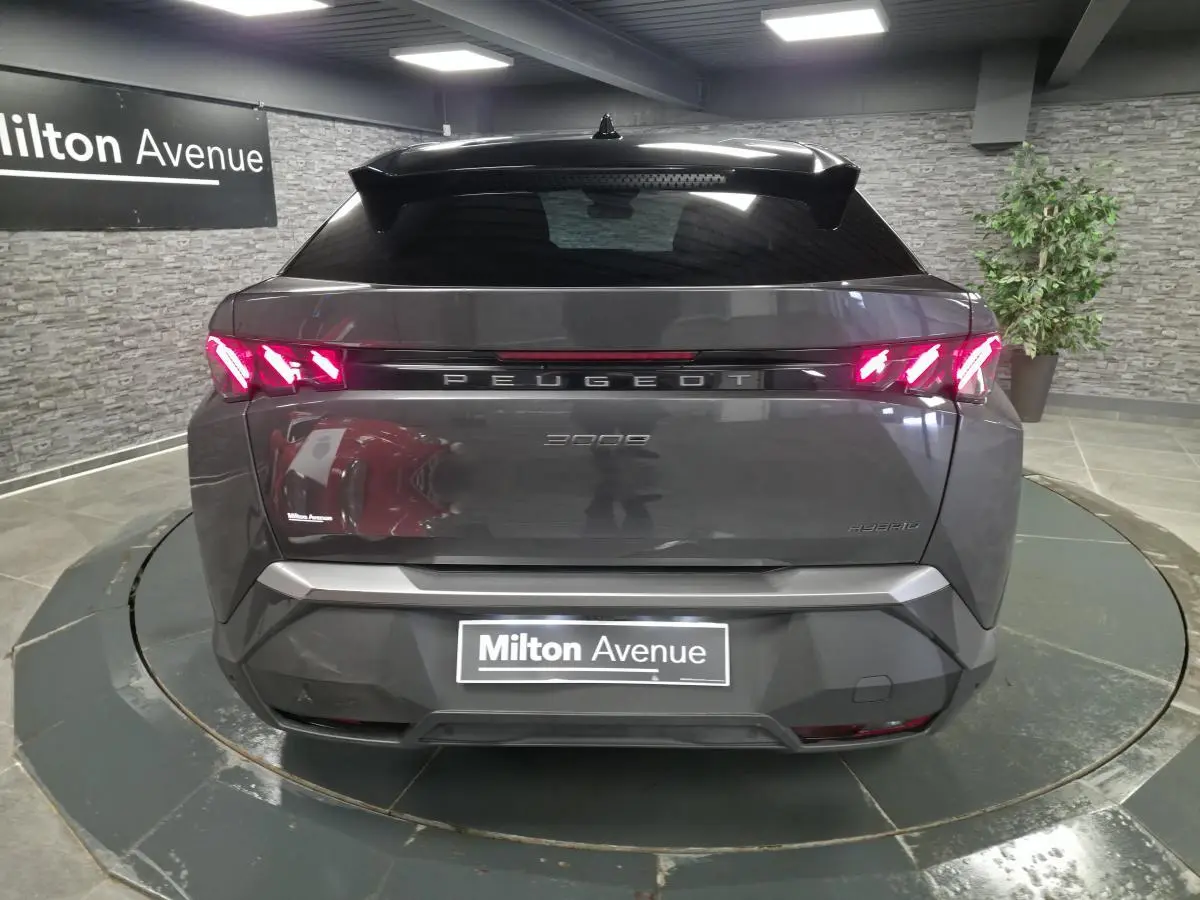 Vue arrière d'un Peugeot 3008 gris métallisé avec feux arrière à griffes LED et bandeau noir laqué lumineux.