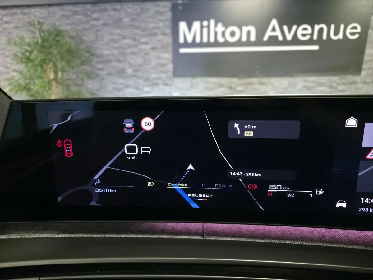 Vue rapprochée de l'écran numérique du tableau de bord du Peugeot 3008 gris, affichant la navigation et les informations de conduite.