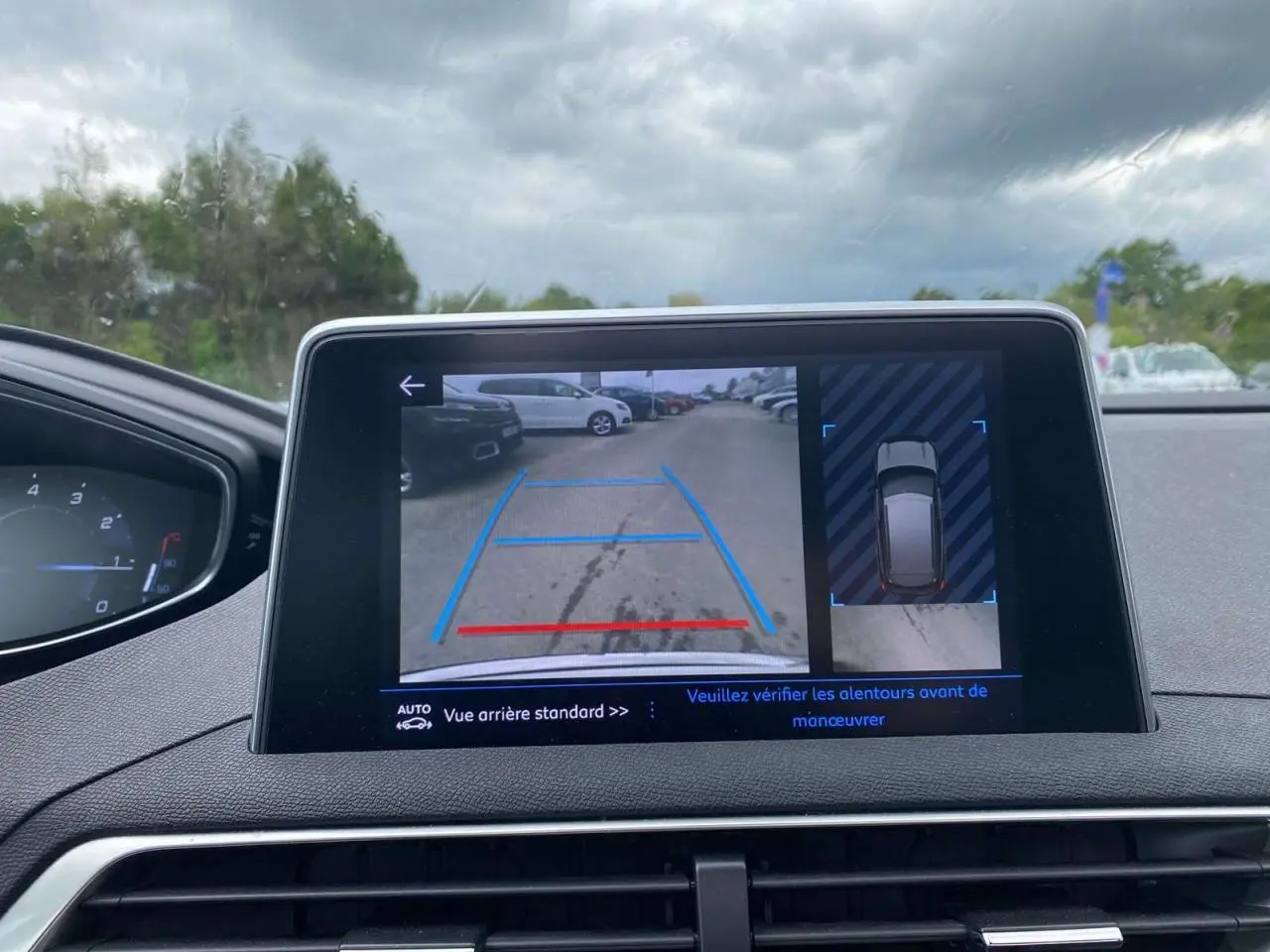 Écran tactile intérieur du Peugeot 3008 blanc 2019 montrant la caméra de recul avec aide au stationnement.