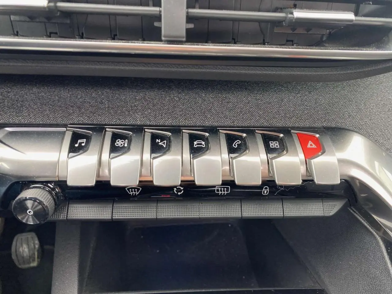 Gros plan sur la rangée de boutons argentés et rouge du tableau de bord du Peugeot 3008 blanc, version Allure+ 2019.