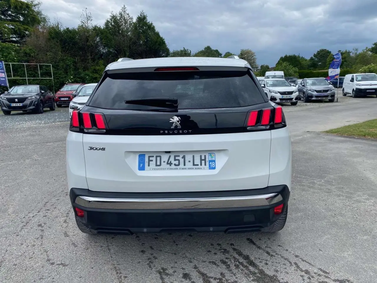 Vue arrière d'un Peugeot 3008 blanc nacré de 2019 avec toit ouvrant panoramique et feux arrière à trois griffes rouges.