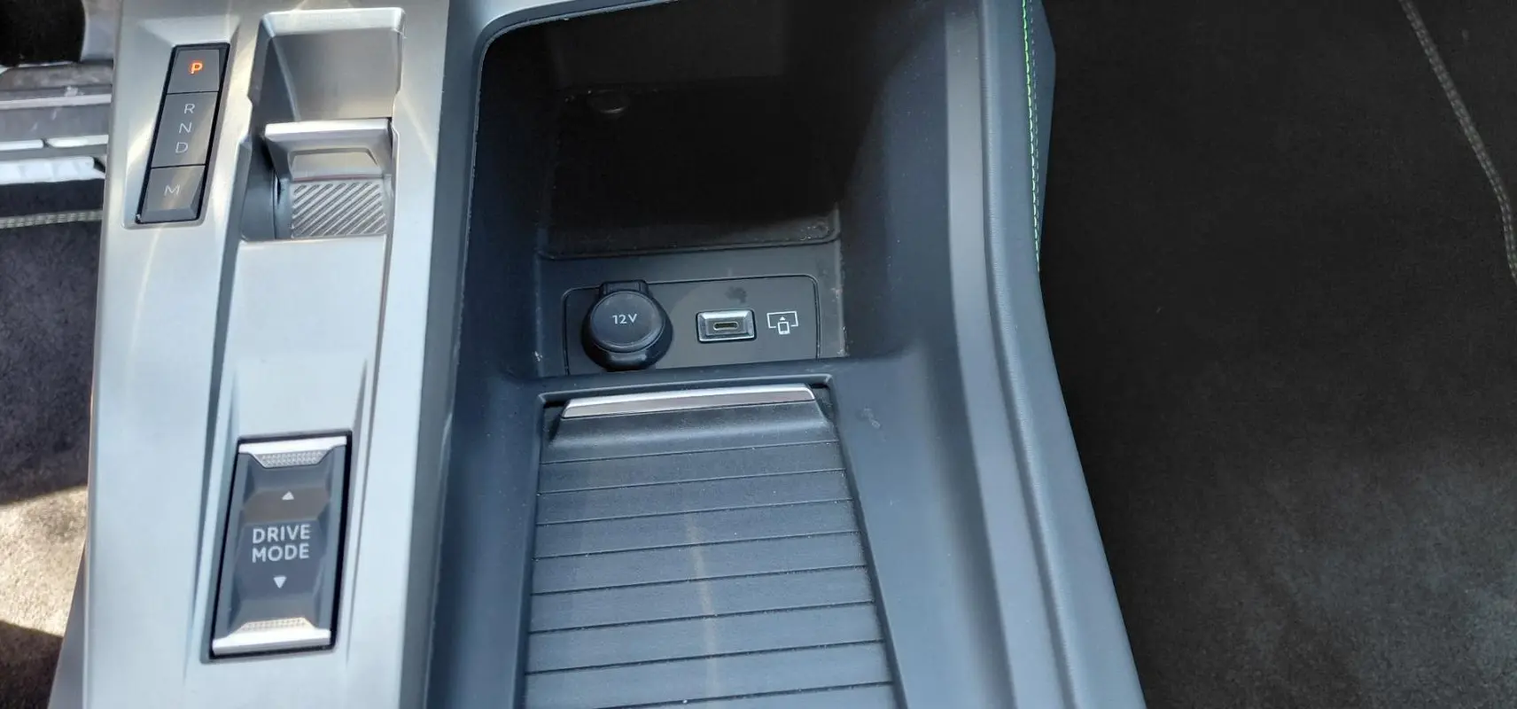 Gros plan sur la console centrale de la Peugeot 308 Hybrid 145 e-DCS6 GT 2025, avec sélecteur boîte auto et port USB.